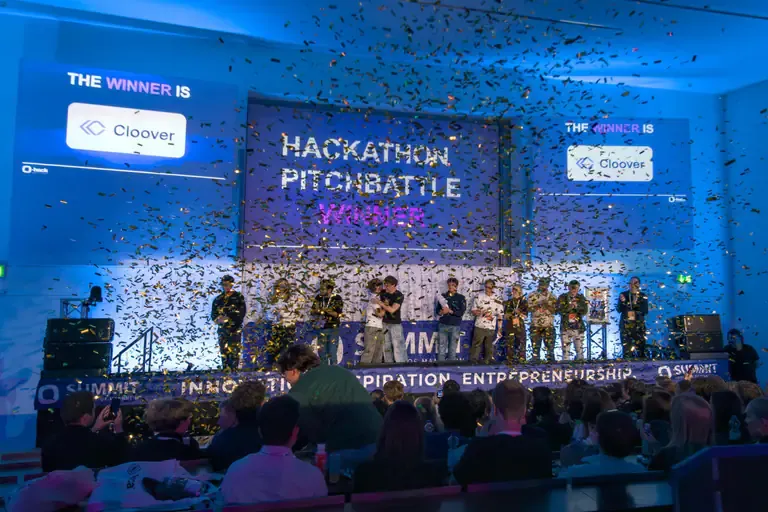 Winning team on stage under falling confetti at the hackathon pitch battle
